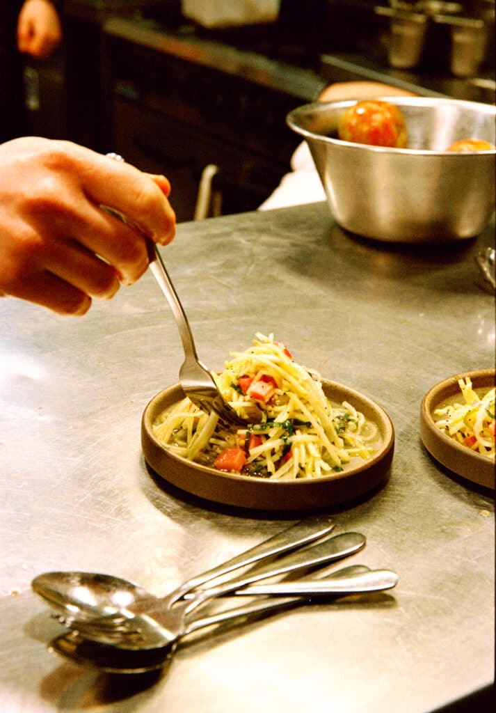 Hand plating a vibrant salad dish